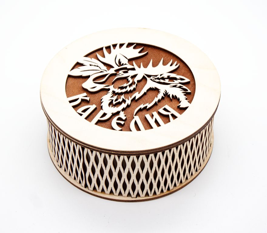 Сувенирная круглая шкатулка которая со сквозной резьбой по стенкам, а на крышке вырезан узор достопримечательности